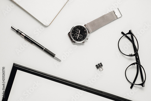 Top view office table desk. Workspace with blank clip board, watch, office supplies, pen and eyeglasses on white background. Flat lay, copy space