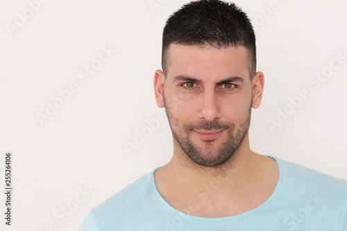 Portrait of young man looking at camera, studio shot on the grey background
