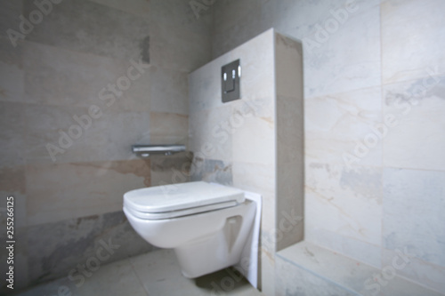 Installation of a new white toilet bowl. Unfinished Interior of repair and renovation bathroom. A bathroom remodeling project and design wetroom. Out of focus. Blurred frame