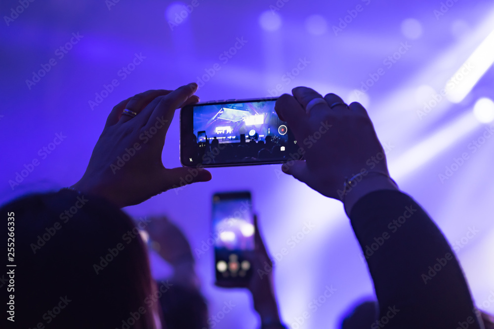 many people who dance and record with the phones at the live music concert many people who dance and record with the phones at the live music concert
