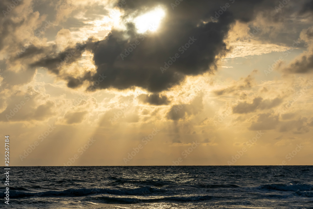 Sunset beach in Florida on the Gulf of Mexico with a bright sky with light shining through the clouds