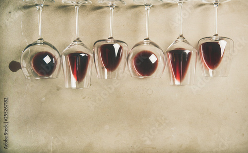 Flat-lay of red wine in different glasses over grey concrete background, top view, copy space. Bojole nouveau, wine bar, winery, wine degustation concept