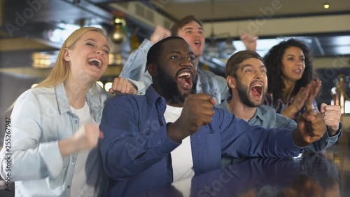 Happy friends watching sports in bar, rejoicing winning game, leisure activity photo