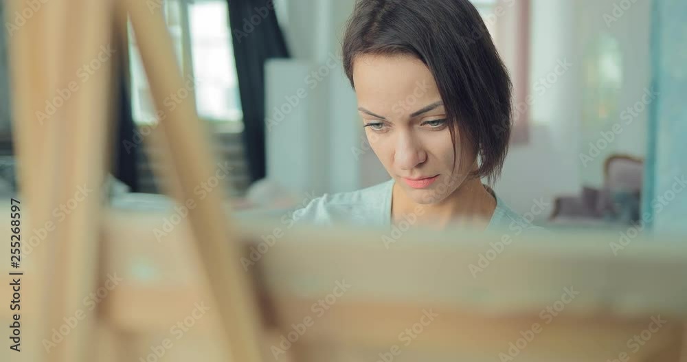 Young cute girl draws at the easel. Portrait view. Young cute girl draws at the easel. Portrait view.