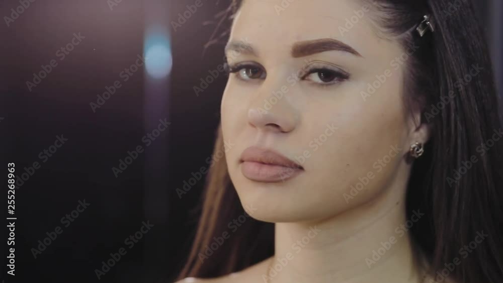 Young girl tweezing her eyebrows in a beauty salon. Eyebrows closeup, look into the camera Young girl tweezing her eyebrows in a beauty salon. Eyebrows closeup, look into the camera