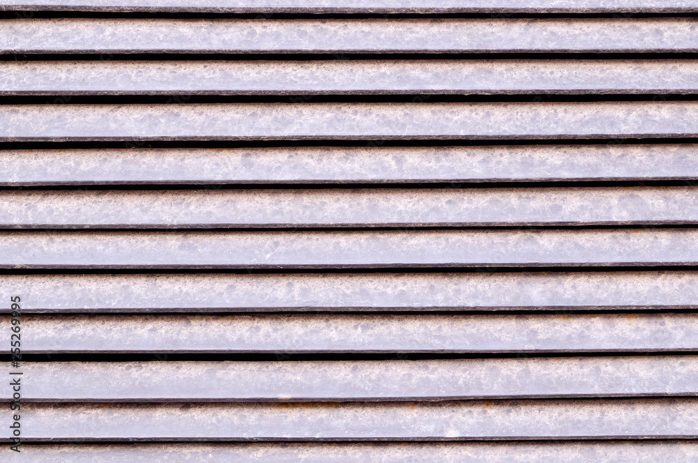 horizontal stripes of dusty metal jalousie exterior. background, texture.