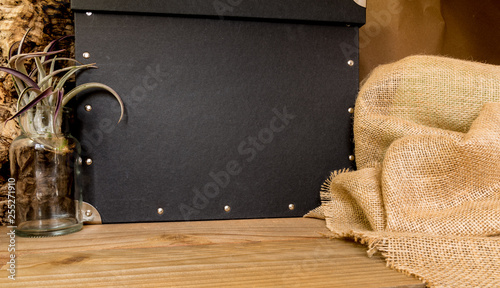 warm and masculin space setting for mocking up products or special messages.  burlap, plant and studded box. photo