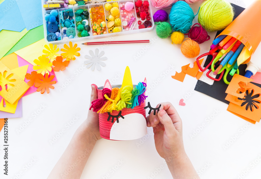 Fototapeta premium child makes a hand-made unicorn out of a tin can. Rainbow hair