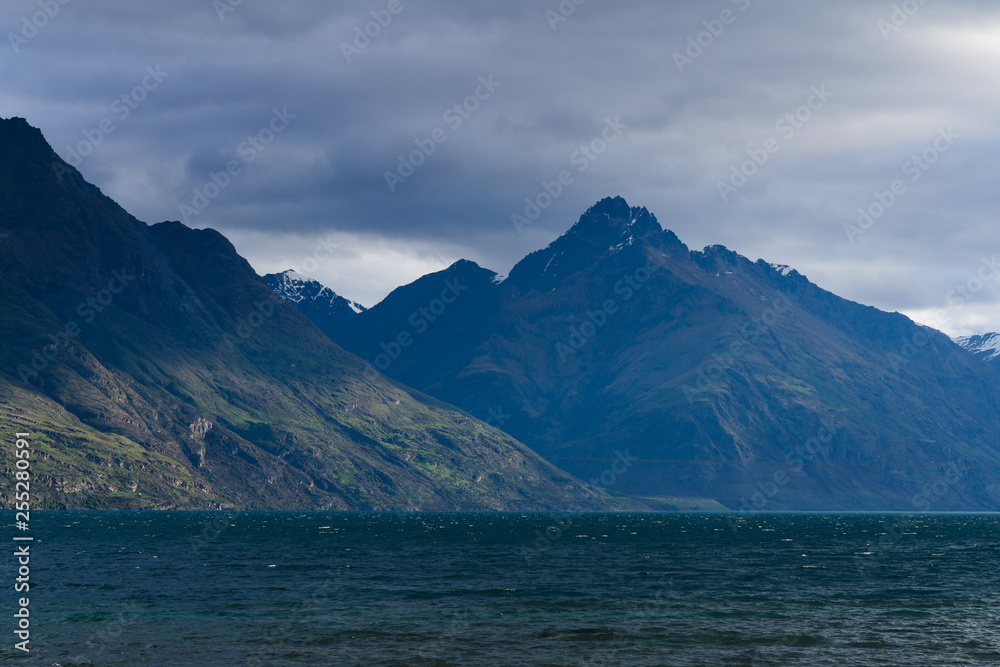 peaceful landscape during sunset with dramatic sky above mountain range, perfect hiking area