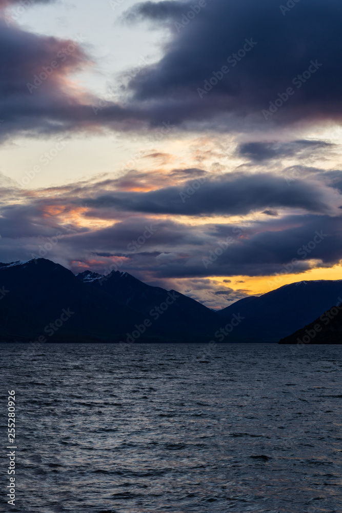 peaceful landscape during sunset with dramatic sky above the lake and mountain range peaceful landscape during sunset with dramatic sky above the lake and mountain range