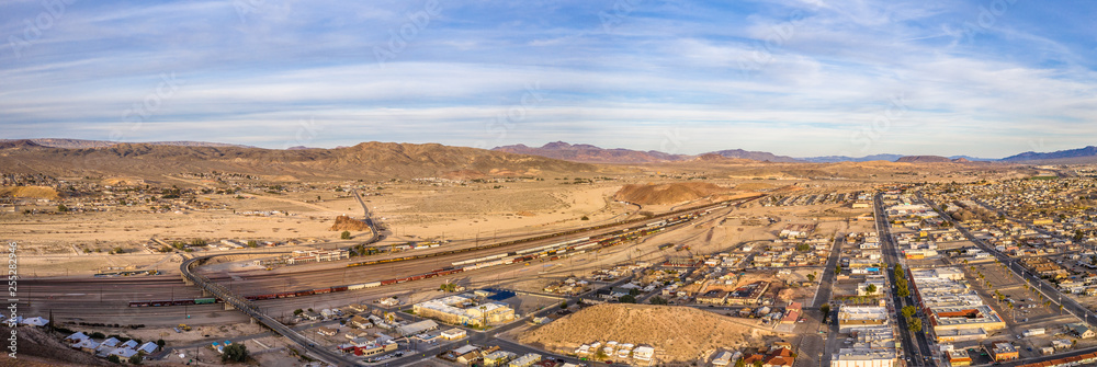 Naklejka premium Aerial view of Barstow community a residential city of homes and commercial property community Mojave desert California USA at sunset. Railway Station and Museum