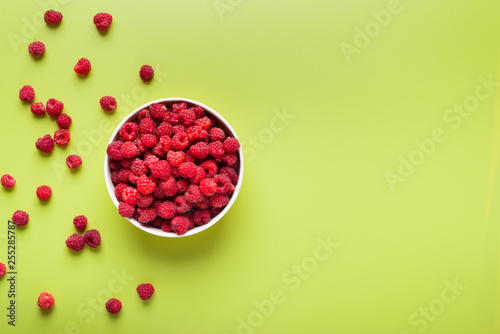 Fresh organic raspberries in a bowl, top view