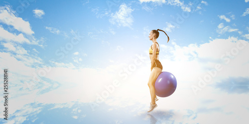 Sporty woman on fitness ball. Mixed media © Sergey Nivens