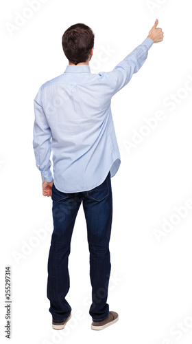 Back view of a man showing thumb up.