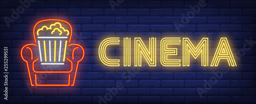 Cinema neon text with popcorn bucket in armchair