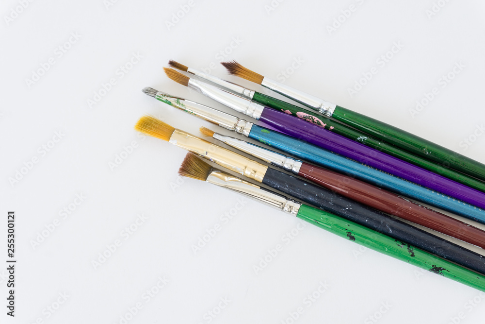 a variety of brushes for painting on a neutral white background