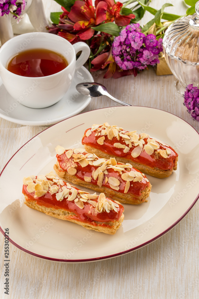 caramel almond eclairs with tea cup on textile napkin caramel almond eclairs with tea cup on textile napkin