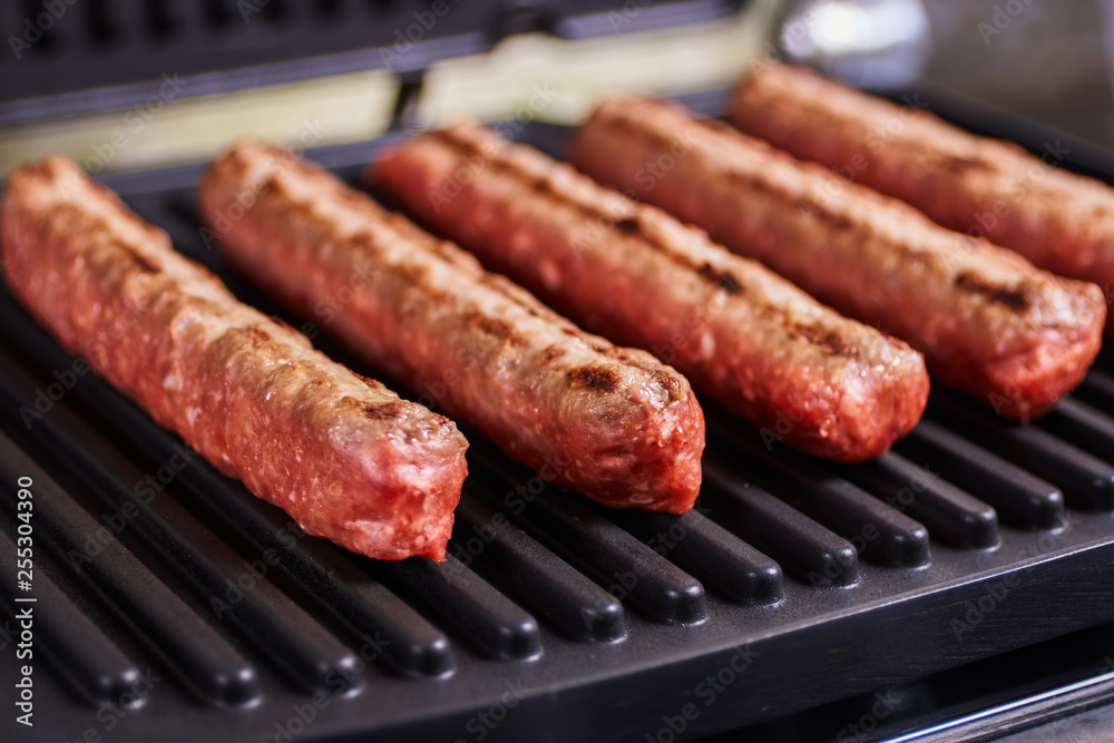 Serbian cevapi, cevapcici, Balkan minced meat kebab. Sausages cooking to grill. Close-up Serbian cevapi, cevapcici, Balkan minced meat kebab. Sausages cooking to grill. Close-up