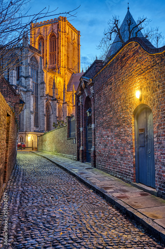 Small cobbled street in York at night with the famous Minster in the back