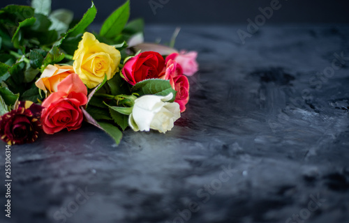 bouquet of colourful roses on black  grey background 