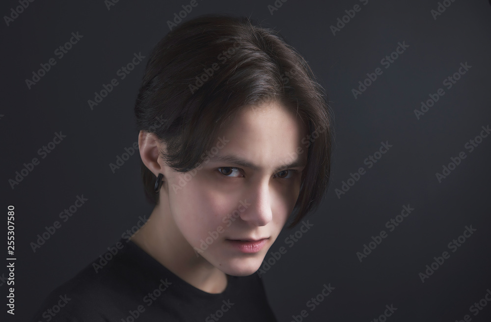Fototapeta premium Portrait of an impulsive beautiful young girl with short hair in a black t-shirt and top