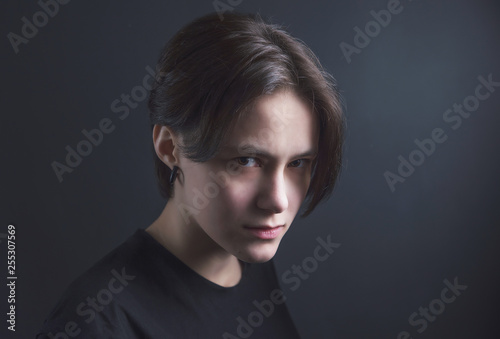 Portrait of an impulsive beautiful young girl with short hair in a black t-shirt and top