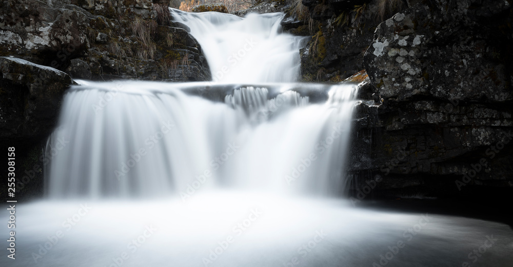 Scene with peaceful waterfall among the mountains Scene with peaceful waterfall among the mountains
