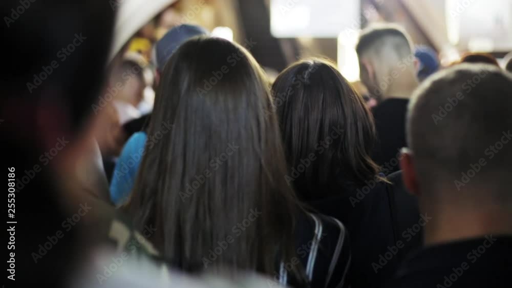 Overpopulation in the subway station of the big city. People moving slowly like zombies in a queue to the escalator.