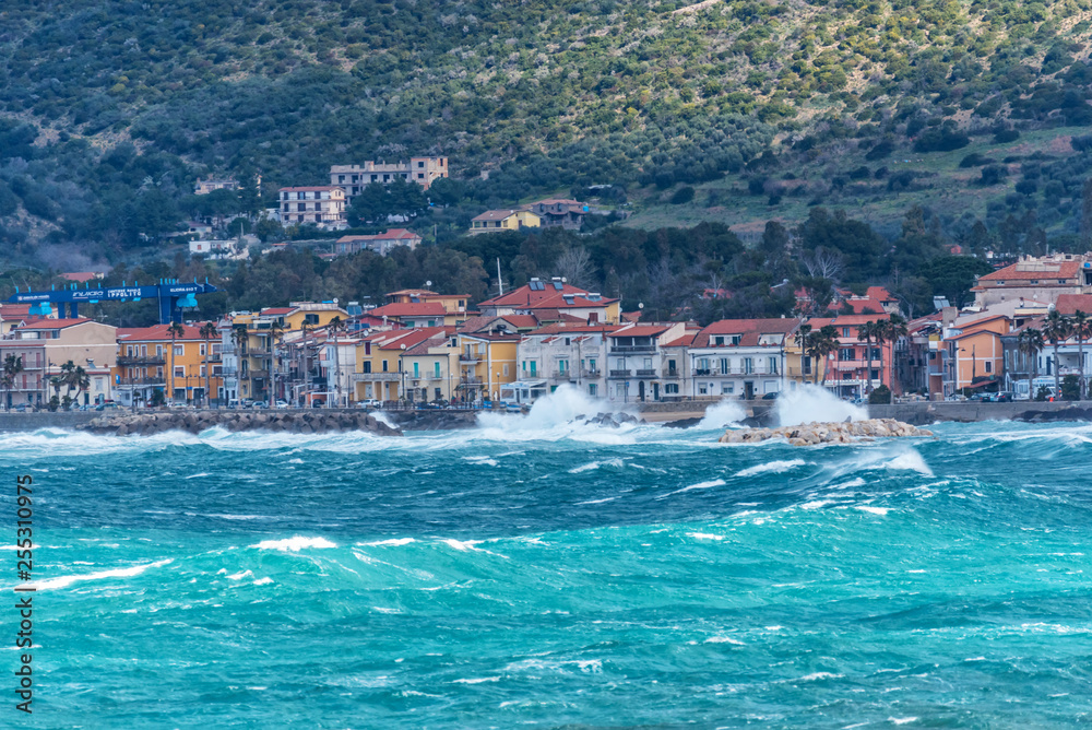 Fototapeta premium Stormy and Windy Mediterranean Sea with a Village in the Distance