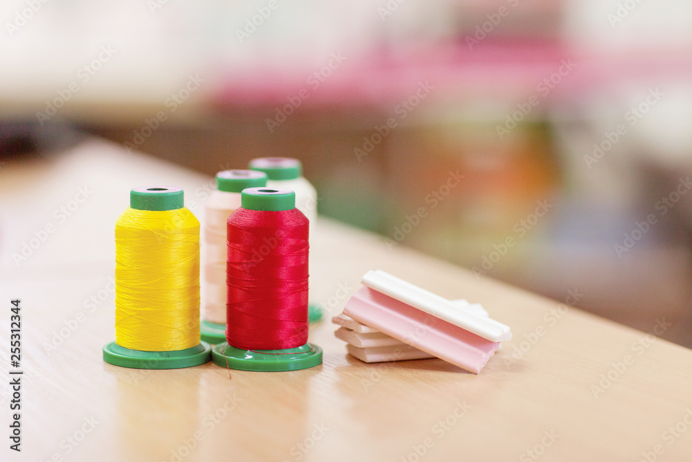 Sewing accessories on a wooden table close-up. Sewing thread and chalk for cutting Sewing accessories on a wooden table close-up. Sewing thread and chalk for cutting