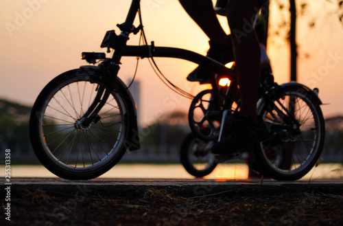 Bike wheels close up image on asphalt sunset road