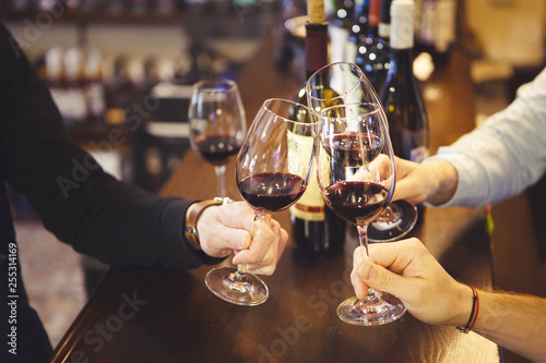 Close up image of peope toasting with glasses of red wine in the restoran.