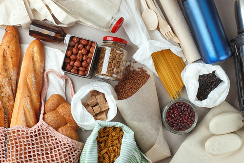Meal in eco cotton bags, glass and paper packaging on table in the kitchen from market. zero waste shopping concept. ban plastic, Bread, nuts, sugar, buckwheat, pasta, beans