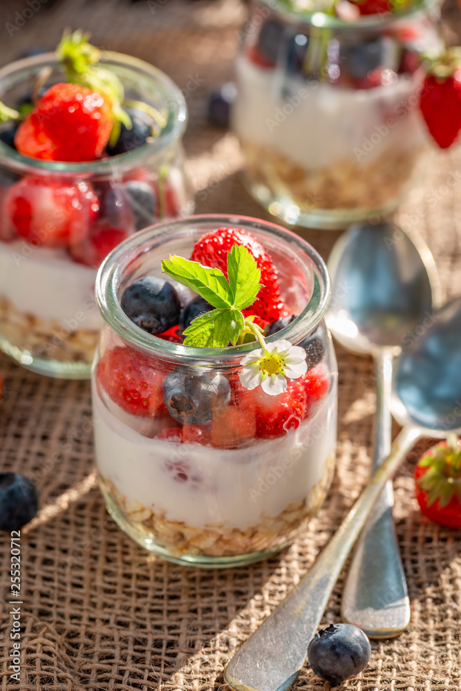 Homemade oat flakes in jar with yoghurt and berries Homemade oat flakes in jar with yoghurt and berries