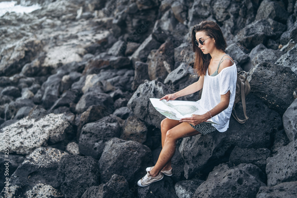 Pretty long hair tourist girl relaxing on the stones near sea. Pretty long hair tourist girl relaxing on the stones near sea.