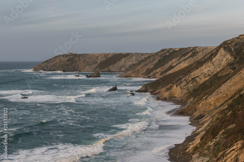 Wavy sea . Breathtaking view of a beach and the cliffs.