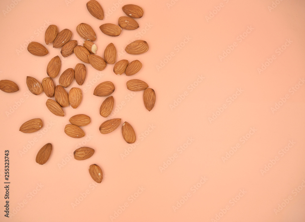 Obraz premium Isolated almond nuts on the live coral solid background
