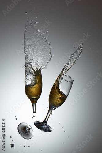 Collision of champagne glasses with shattered glass and champane splash photo