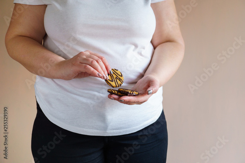 fattening food, high-calorie snack. weight loss, dietary, balanced nutrition. overweight woman eating unhealthy chocolate cookies