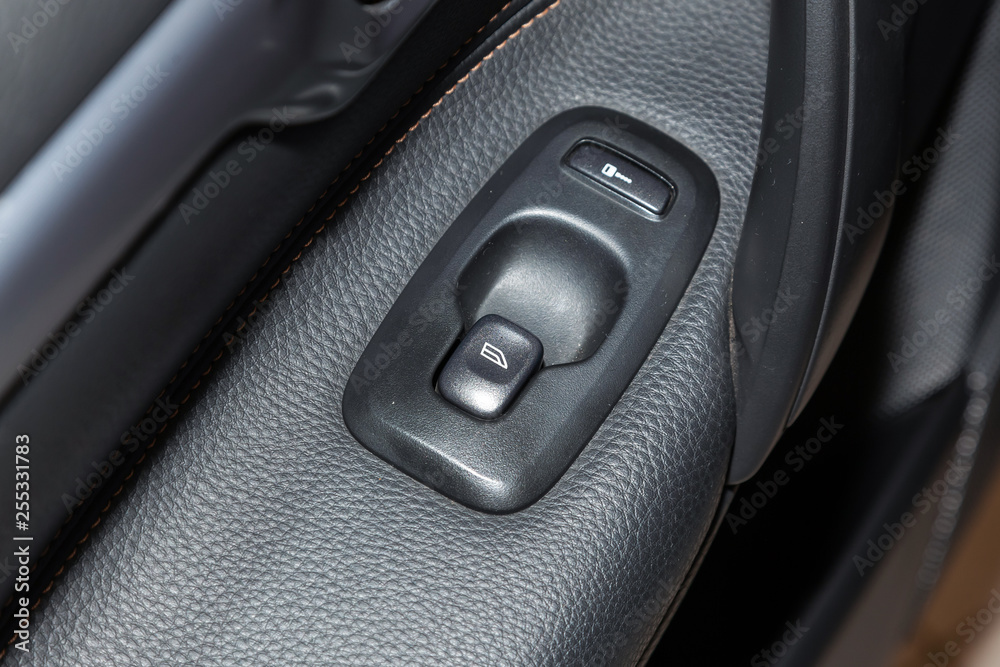 Close-up on windows control buttons on the door in the interior of an modern black car in gray after dry cleaning