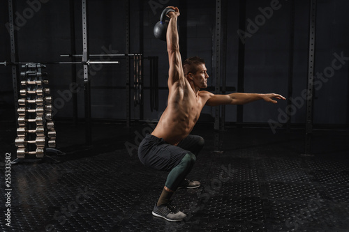 Kettlebells swing exercise man workout at gym. Crossfit training © Arsenii
