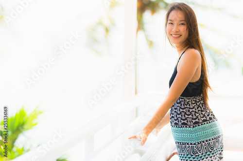 Portrait beautiful young asian woman happy and smile with travel in hotel resort neary sea and beach