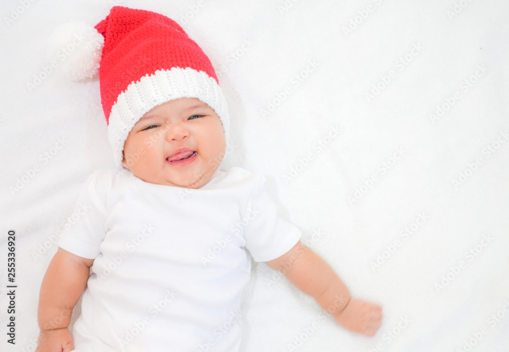 Happy newborn baby wear white shirt and Christmas kneeting hat on white background Happy newborn baby wear white shirt and Christmas kneeting hat on white background