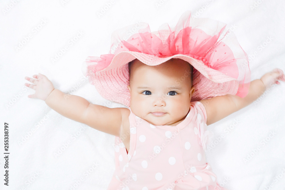Asian baby girl wears pink shirt, pink beach hat on white background Asian baby girl wears pink shirt, pink beach hat on white background