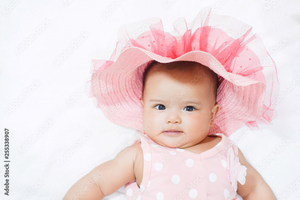 Asian baby girl wears pink shirt, pink beach hat on white background Asian baby girl wears pink shirt, pink beach hat on white background