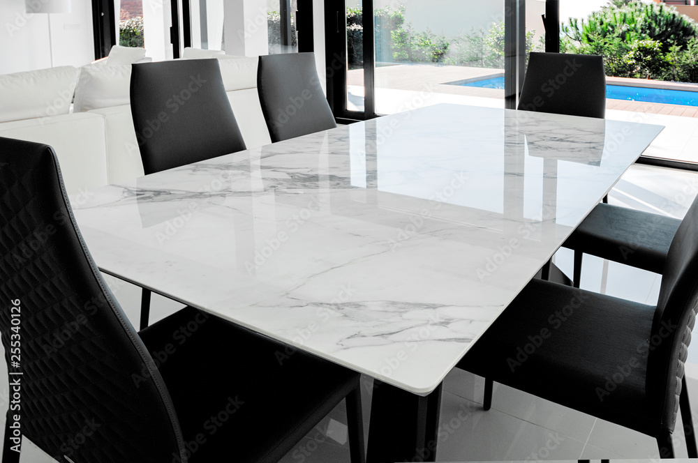 Luxurious marble dining table with black chairs.