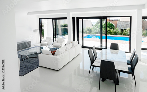 Luxurious and modern living room, dining with large windows with access to the pool. . Luxurious furniture, sofa, table and chairs.