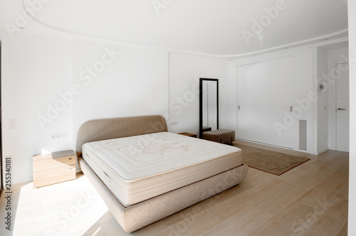 Obraz na płótnie Minimalistic style bedroom in brown and beige tones with new mattress. w salonie