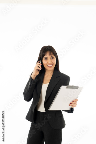 Successful young business woman talking on phone holding a folder. Isolated on white background.