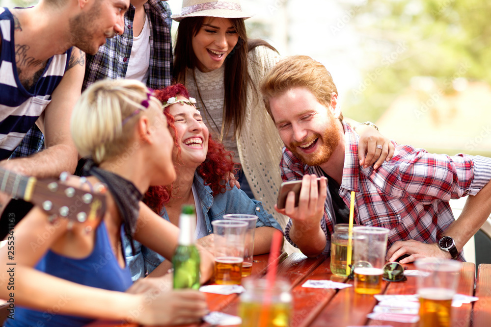 Cheerful group laughing at something interesting on mobile phone